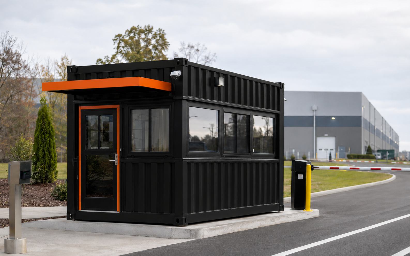 Black and orange modular security booth with wide visibility windows at a commercial entrance